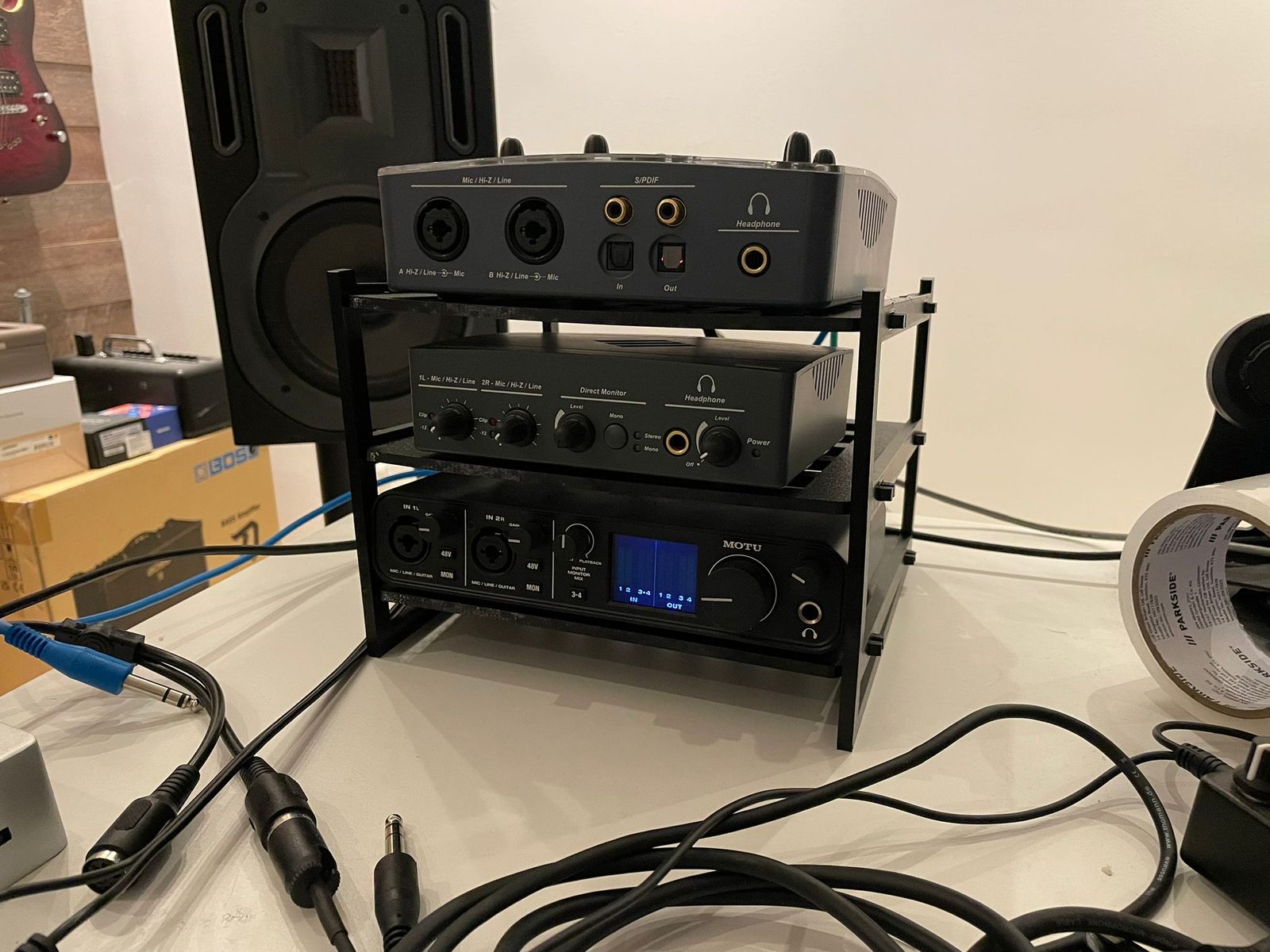 Three audio interfaces stacked in a black 3D-printed rack: E-MU 0404 USB on top, E-MU Tracker Pre in the middle, MOTU M4 at the bottom